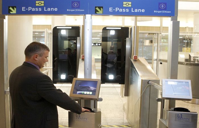 A man puts his biometric passport on a scanner at an automatic border control point during a media presentation at Zurich-Kloten airport December 1, 2010. The machine, designed to replace passport control officers, can align the data of biometric passports of travellers from Switzerland or EU countries leaving the Schengen area, to image scans taken of the passenger's face. If they match, they may cross the border. The system begins a six-month trial today.  REUTERS/Arnd Wiegmann (SWITZERLAND - Tags: TRAVEL TRANSPORT IMAGES OF THE DAY) - BM2E6C11AR701