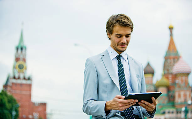 Handsome Young Businessman in Moscow holding Digital Tablet